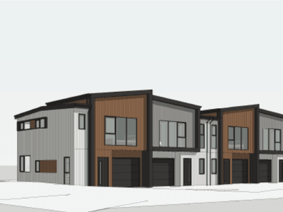 Row of contemporary two-story townhouses with wood and gray siding, attached garages, and large front windows along a street.